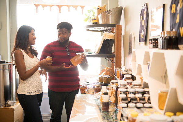 couple buying honey jar inside store