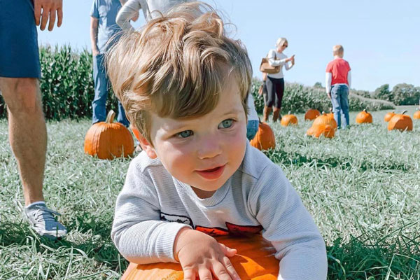 Kid playing on pumpkin patch