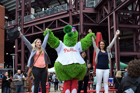 Phillies Mascot posing with two other ladies