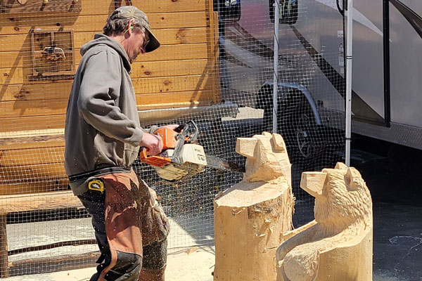 A guy carving wood using chainsaw