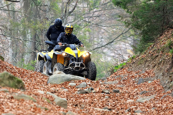 two guys riding ATV thru trails
