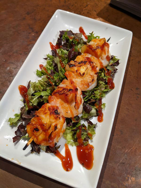 grilled shrimp served on top of salad