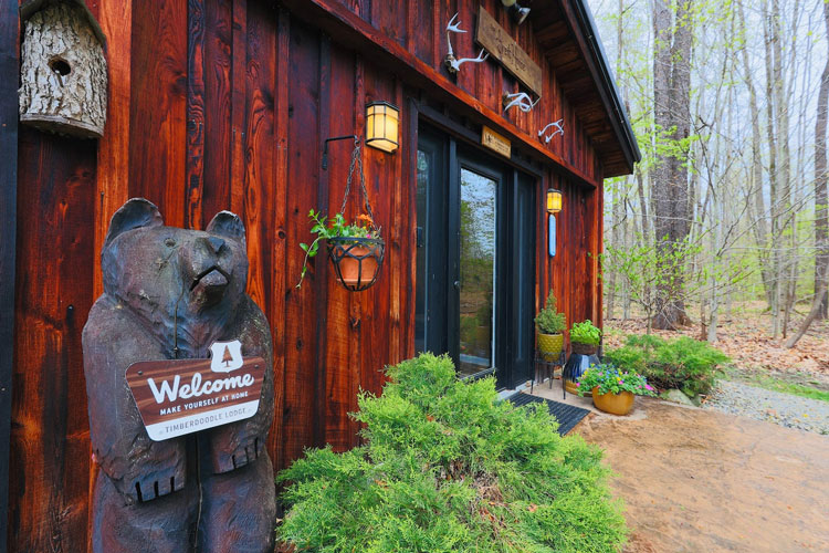 A wood building with a statue of a bear holding a sign