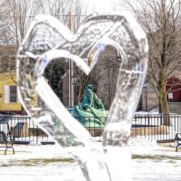 A sculpture of a person in a park view from a heat shaped ice carve