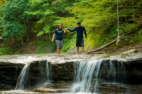 couple walking in water holding hands