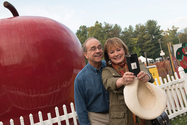 Sweet couple taking a selfie with Giant Apple behind
