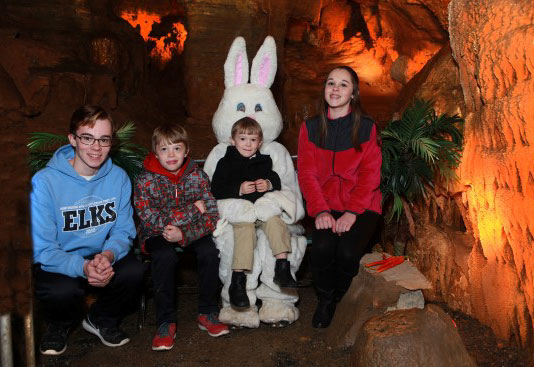 A group of people posing with a person in a rabbit garment