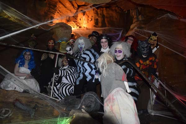 people dressed in halloween costumes inside cavern
