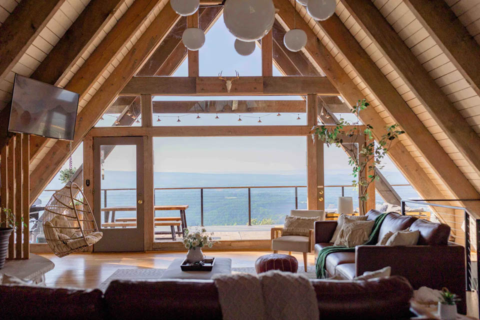 A room with a view of the ocean and a deck with chairs