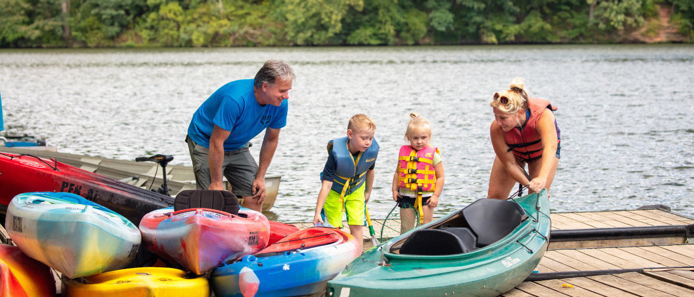 two kids with their grand parents on deck with kayaks