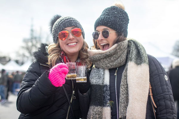 two ladies holding brews in hands