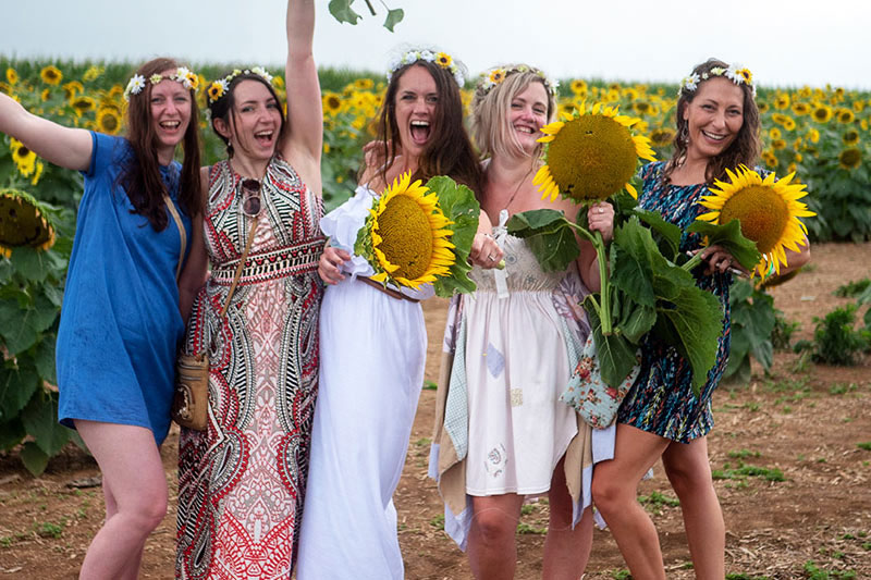 group of ladies holding sunflowers on farm