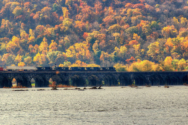 fall foliage behind rail bridge on susquehanna river