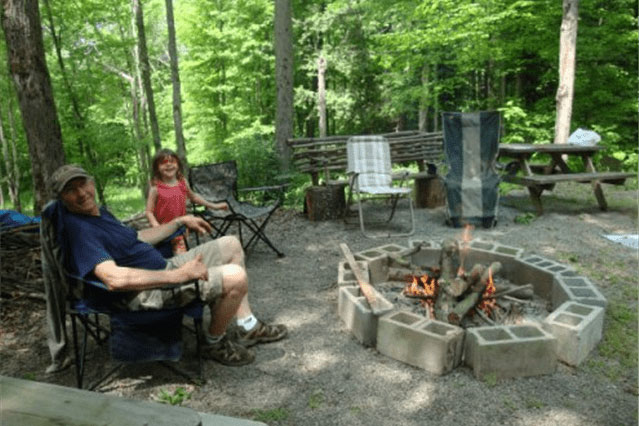 happy couple sitting in chairs near fire pit