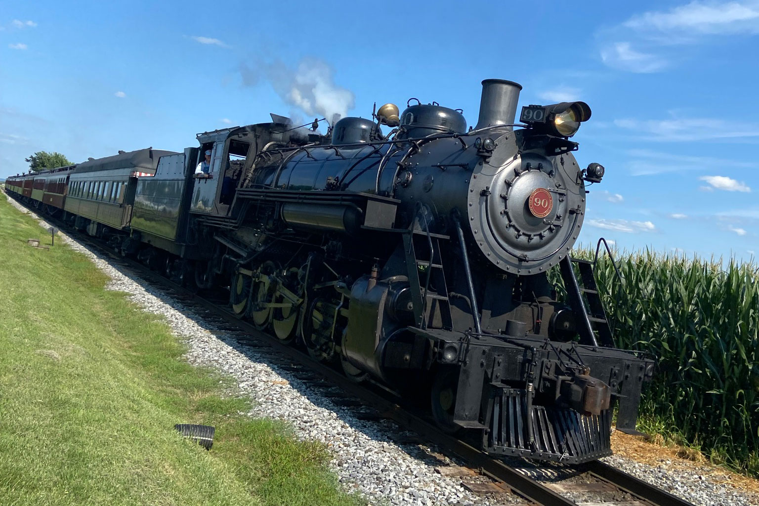 a steam rail wagon passing by fields