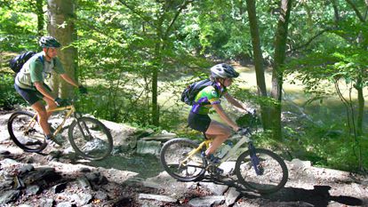 couple biking trail at wissahickon valley park with gear on