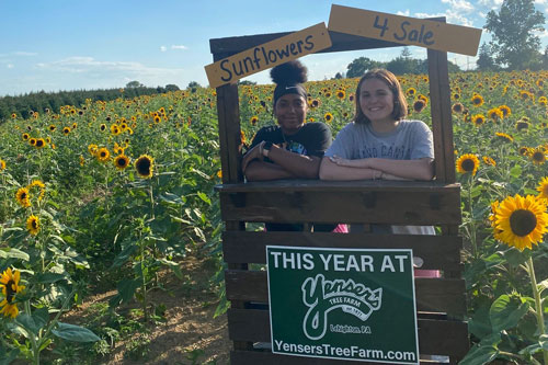 two ladies posing for photo at photobooth on sunflower farm