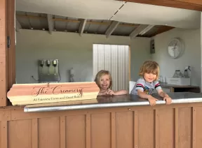 two kids inside creamery Stand