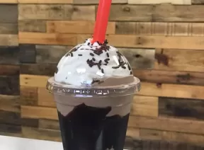 chocolate milkshake topped with whipping cream on top