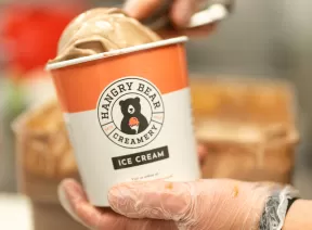ice cream being scooped into pint container