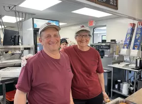 Man and woman behind a counter at a creamery