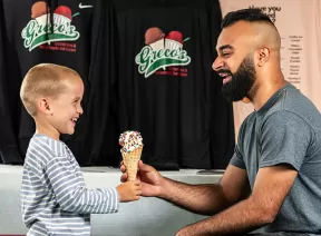 Older man giving a little boy and ice cream cone
