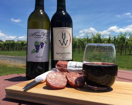 Two bottles of wine and a meat and cheese plate at Happy Valley Vineyard and Winery