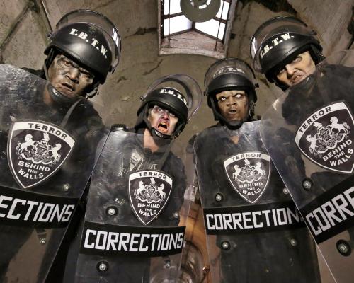 spooky dressed corrections officers holding hand shield