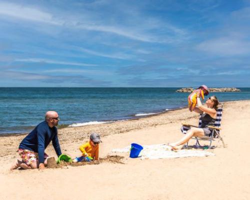 Family enjoying on beach by lake