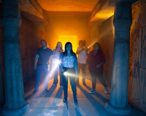 group of people holding torch lights inside a dark room