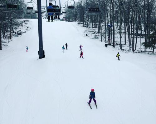 people skiing next to Chair lift