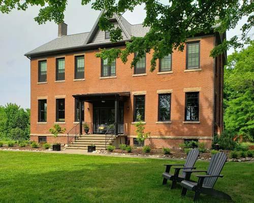 two camp chairs infront of a large brick house