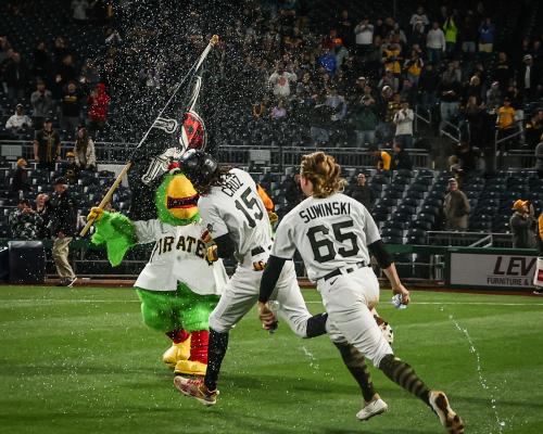 two players and mascot running on ground