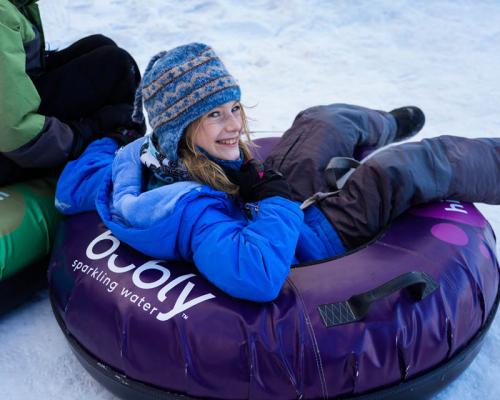 a kids sitting in snow tube