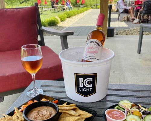 wine served on a glass with nibble on plate