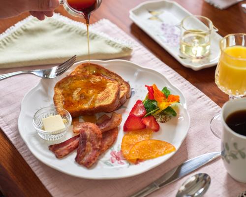 breakfast with french toast eggs bacon and cut fruit