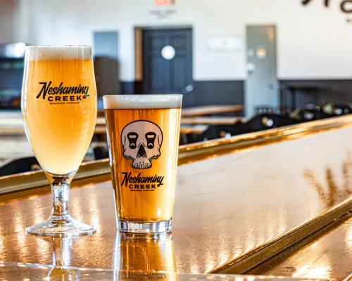 beer poured in glasses and paced on bar counter