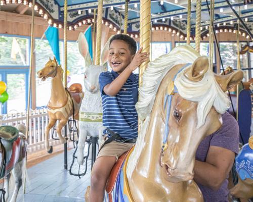 kids riding on carousel at peddlers village giggleberry fair