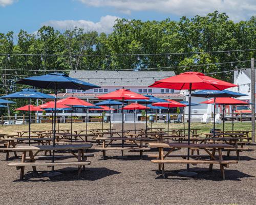 outdoor seating under red and blue umbrellas at Warwick farm brewing