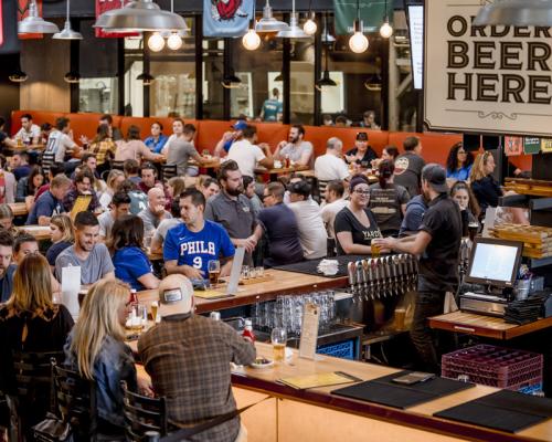 people enjoying beer seating inside yard brewing company