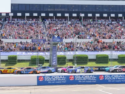 Race cars on a racetrack with fans in the stands