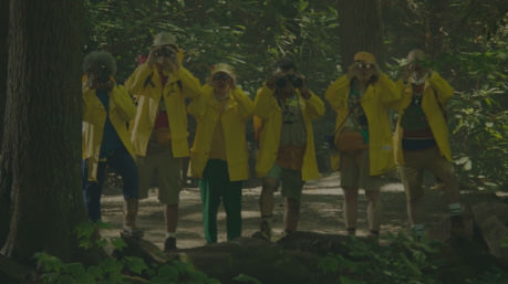 People in yellow coats looking through binoculars